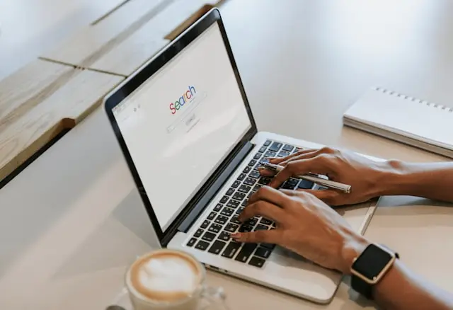 Une femme tape à l'ordinateur. Elle est peut-être copywriter SEO freelance.